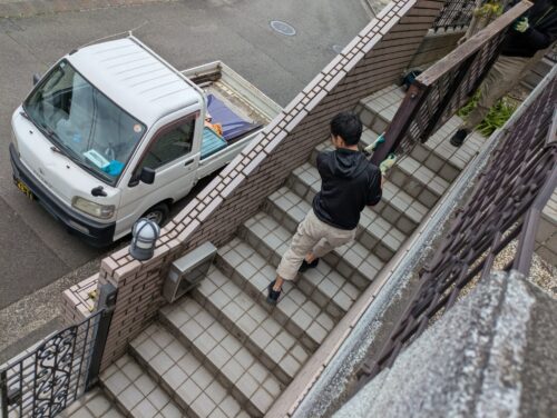 解体したウッドデッキ材を階段で運び出し