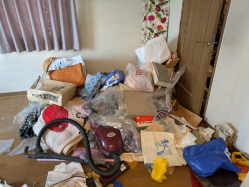 ゴミに埋もれた洋室の残置物処分前